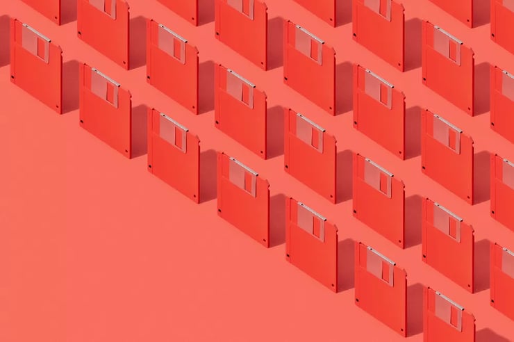 A vibrant red background adorned with numerous floppy disks to mimic tech innovation