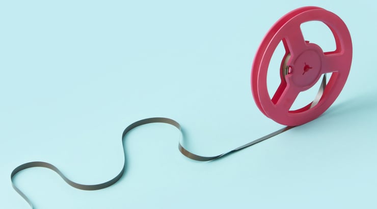 Vintage film reel against a vibrant blue backdrop