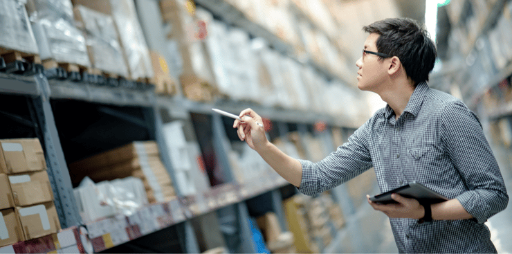 An employee uses inventory management techniques to improve efficiency in the stockroom.